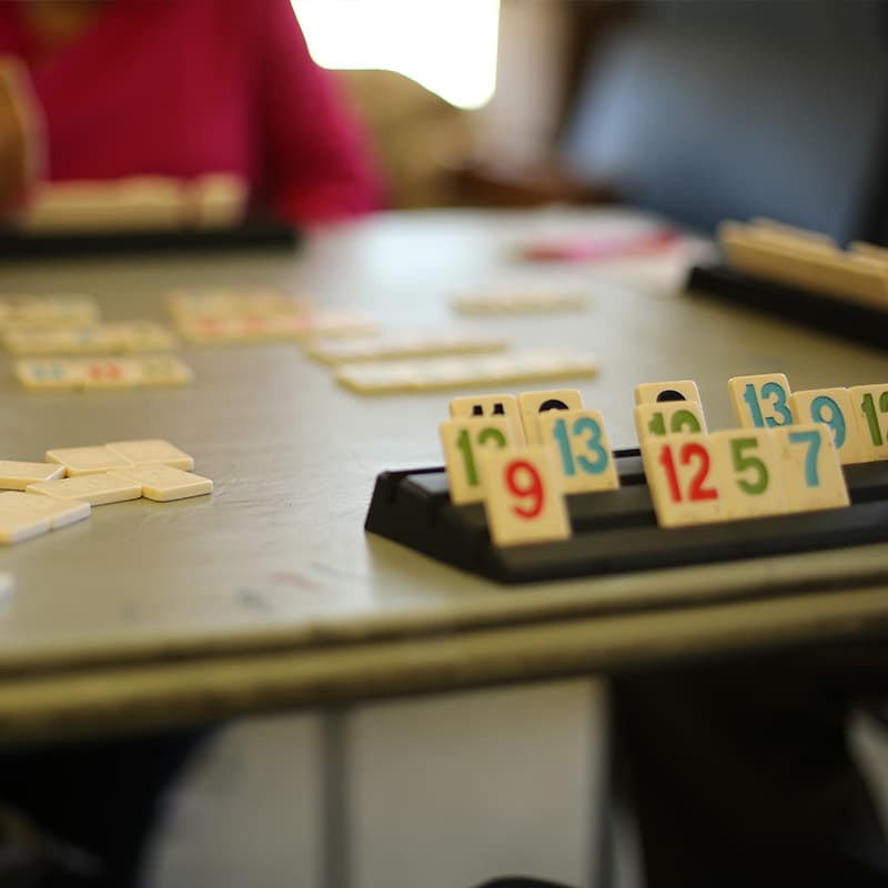 Two older adults playing a game at a table with numbers on display